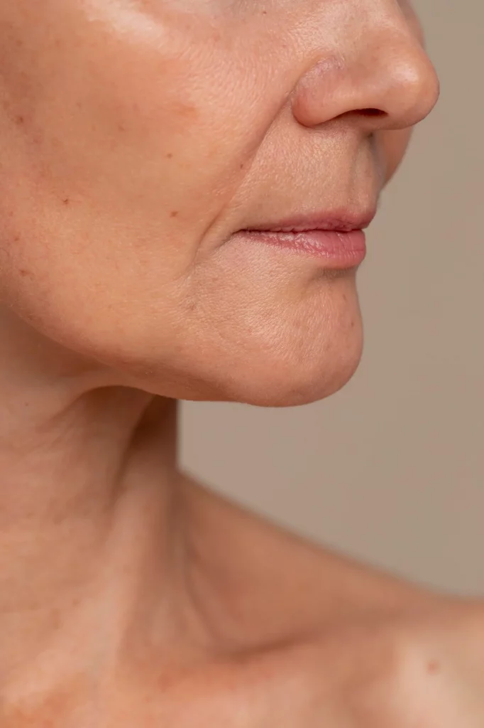 Mujer recibiendo tratamiento facial antienvejecimiento en clínica de belleza